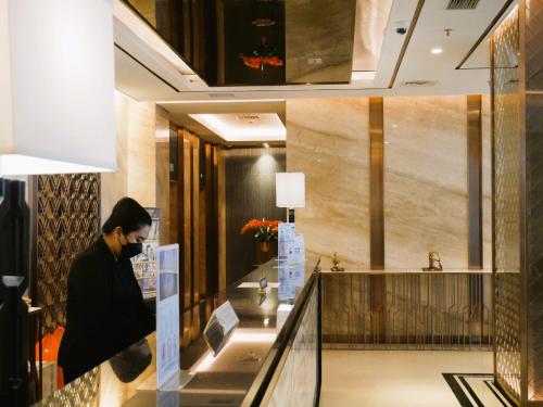 a man wearing a mask in a hotel lobby at Meisterstadt Pollux Habibie in Batam Center