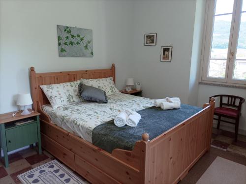 a bedroom with a wooden bed with towels on it at Il giardino di San Martino in Saliceto