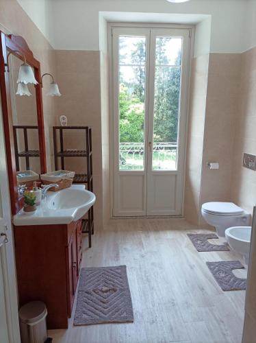 a bathroom with two sinks and a toilet and a door at Il giardino di San Martino in Saliceto