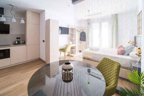 a living room with a glass table and green chairs at BOUTIQUE APARTMENTS- LA GLORIA 1908 in Almería