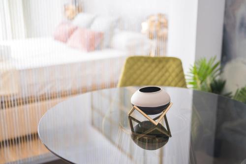 a glass table with a vase on top of it at BOUTIQUE APARTMENTS- LA GLORIA 1908 in Almería