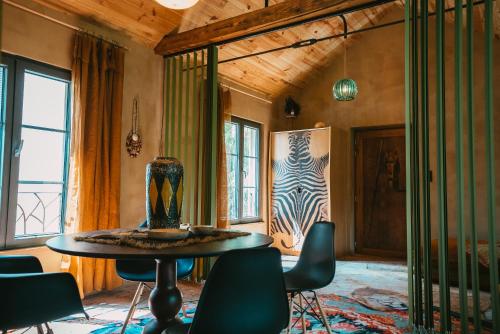 Cette chambre comprend une table avec des chaises et un vase. dans l'établissement Domaine Bohème I art de vivre, à Guebwiller