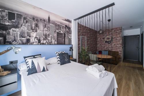 a bedroom with a large white bed with a brick wall at BOUTIQUE APARTMENTS- LA GLORIA 1908 in Almería