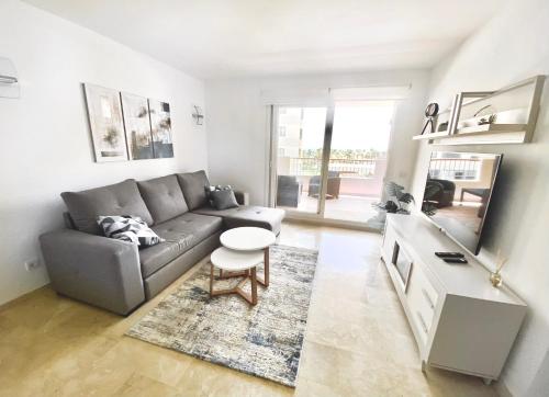 een woonkamer met een bank en een tafel bij New apartment with sea view and pool in Torrevieja