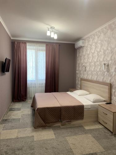 a bedroom with a large bed and a window at Hotel Dobrodiy in Vinnytsya
