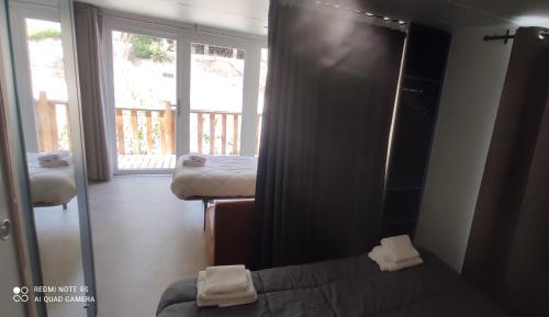 - un miroir dans une chambre avec un lit et une fenêtre dans l'établissement Domaine des voiles de Pierrefeu, à Pierrefeu-du-Var