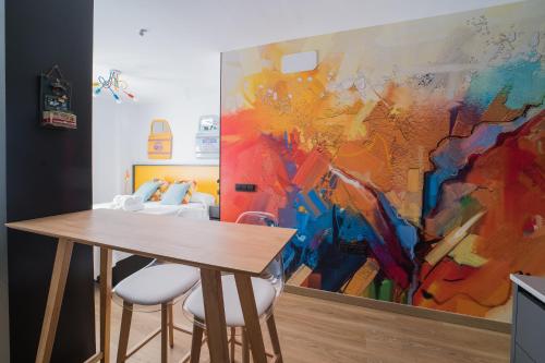 a dining room with a painting on the wall at BOUTIQUE APARTMENTS- LA GLORIA 1908 in Almería