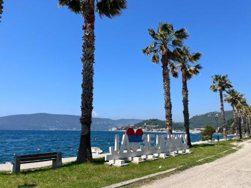 a white bench with two hearts on it next to the water at Apartment’s Maric - Zelenika,Herceg Novi in Zelenika