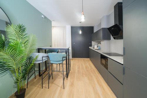 a kitchen with a table and some chairs and a plant at BOUTIQUE APARTMENTS- LA GLORIA 1908 in Almería
