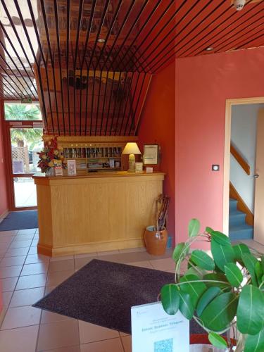un restaurant avec un comptoir dans une salle dans l'établissement Maison Hôtel Aux Cerisiers, à La Forêt-Fouesnant