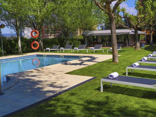 a swimming pool with lounge chairs next to a resort at Ciutat de Granollers in Granollers