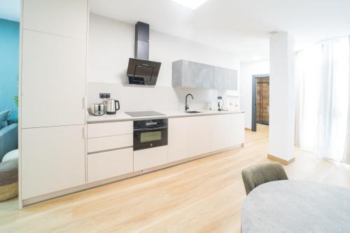 a kitchen with white cabinets and a sink at BOUTIQUE APARTMENTS- LA GLORIA 1908 in Almería