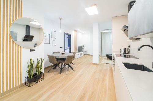 a kitchen and living room with a table and a mirror at BOUTIQUE APARTMENTS- LA GLORIA 1908 in Almería
