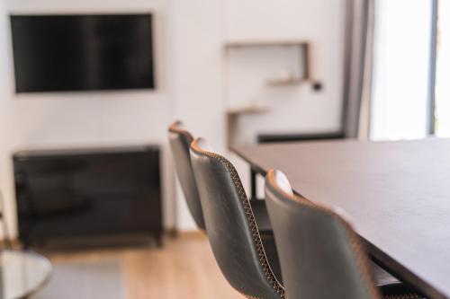 a table and chairs with a table and a television at BOUTIQUE APARTMENTS- LA GLORIA 1908 in Almería
