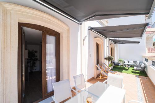 a dining room with a table and white chairs at BOUTIQUE APARTMENTS- LA GLORIA 1908 in Almería