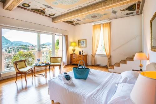 Villa Sassa Hotel, Residence & Spa - Ticino Hotels Group في لوغانو: غرفة نوم بسرير وطاولة مع كراسي