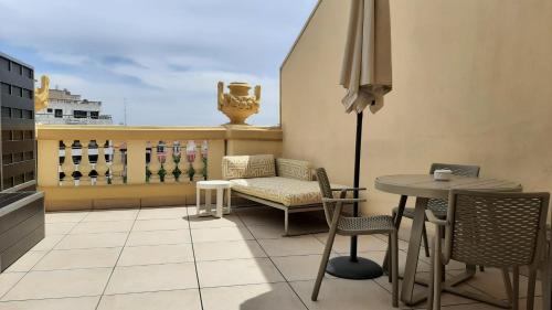 a balcony with a table and chairs and an umbrella at Hotel Sardinero Madrid in Madrid
