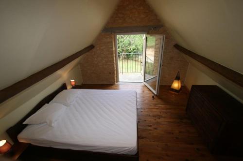 une chambre avec un lit blanc et une fenêtre dans l'établissement Sarlat, 600 m à pied du centre historique, maison La Salamandre, à Sarlat-la-Canéda