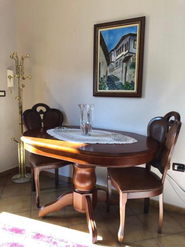 mesa de comedor con 2 sillas y una pintura en Villa Garden, en Berat