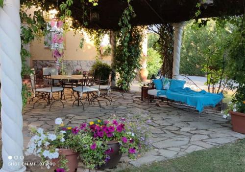 a patio with a table and chairs and flowers at Villa Prana in Avila