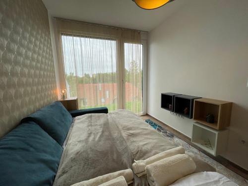a bedroom with a large bed and a large window at Bárdo Apartman in Balatonlelle