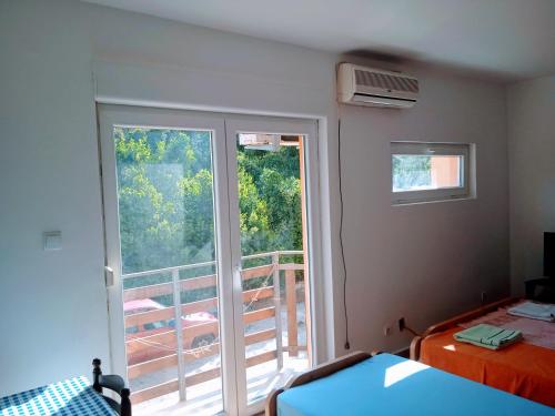 una camera con letto e finestra con balcone di Apartmani Vukovic a Tivat