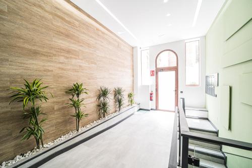 a hallway with potted plants on the wall at BOUTIQUE APARTMENTS- LA GLORIA 1908 in Almería