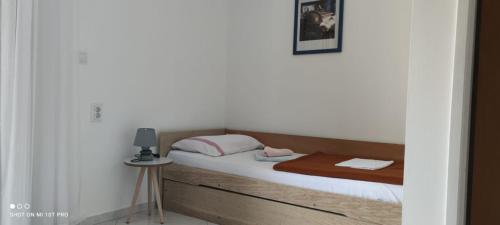 1 dormitorio con 1 cama y 1 mesa con lámpara en House Irena en Budva