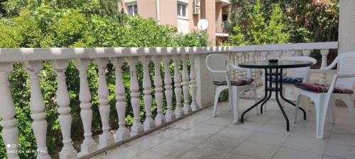 a white fence with a table and chairs on a patio at House Irena in Budva