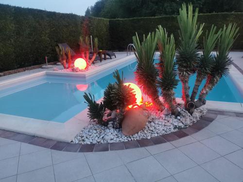 una piscina con palmeras y luces junto a ella en Casa di Campagna B&B La Corte Ferrara, en Ferrara