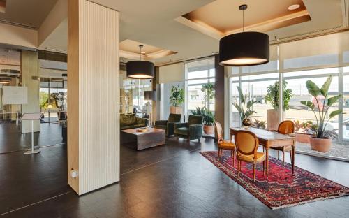 an office lobby with a table and chairs at Sercotel Plaza Feria in Zaragoza