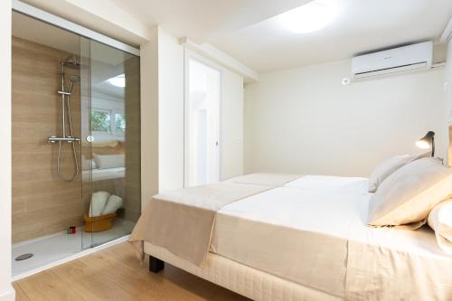 a white bedroom with a shower and a bed at Higueron Rental Playa Mira in Benalmádena