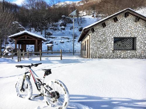 a bike parked in the snow in front of a building at Le Tre Dimore - Rifugio Aceroni in San Biagio Saracinesco