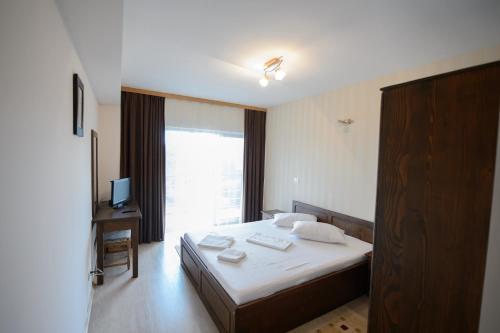 um quarto de hotel com uma cama e uma janela em Tuya Residence em Eforie Nord