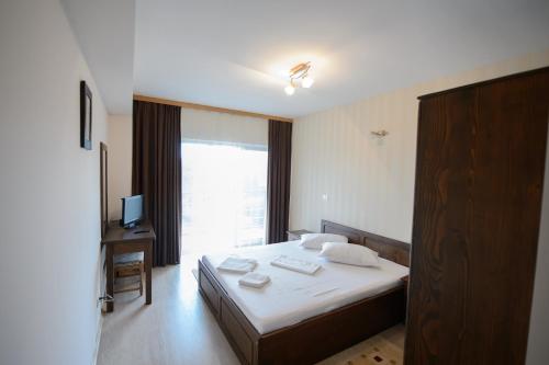 a hotel room with a bed and a window at Tuya Residence in Eforie Nord
