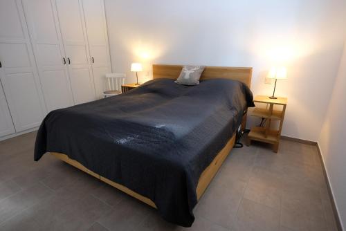 a bedroom with a bed with a black blanket on it at AusZeit Schönwald in Schönwald