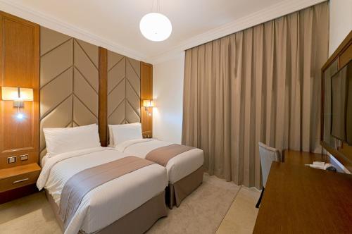 una habitación de hotel con una cama grande y una mesa en TIME Moonstone Hotel Apartments, en Fujairah