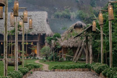 a house with a thatch roof and a pathway at Dinh Gia Trang - Homestay & Coffee in Yên Bái