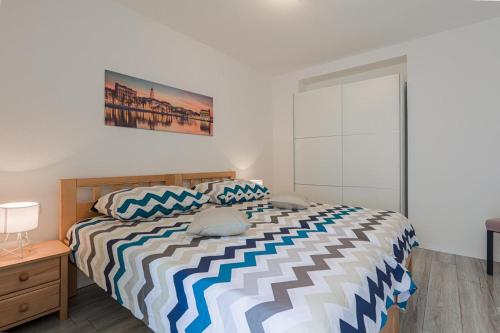 a bedroom with a bed with a striped comforter at Apartman Marica in Split