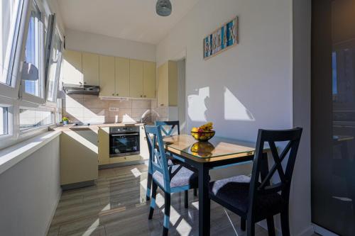 a kitchen with a table and two chairs and a kitchen with a counter at Apartman Marica in Split