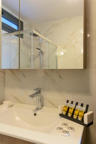 a bathroom with a sink and a mirror at Elounda Blue Waves in Elounda