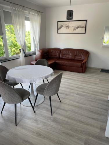 a living room with a couch and a table and chairs at Apartamenty i Pokoje DIMAN in Mrągowo
