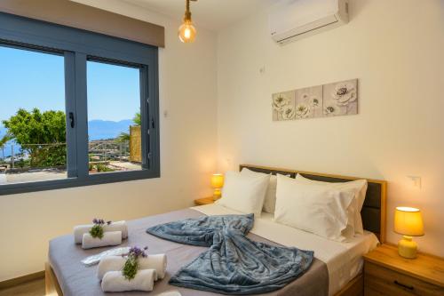 Schlafzimmer mit einem Bett und einem großen Fenster in der Unterkunft Elounda Blue Waves in Elounda