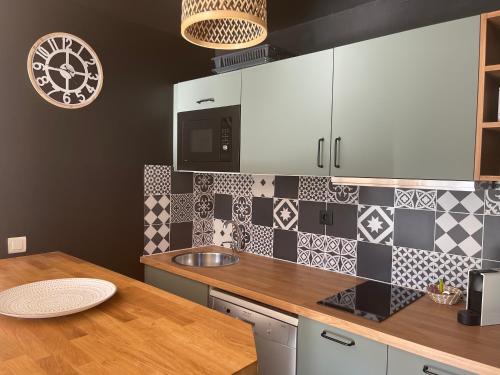 une cuisine avec des armoires blanches et un comptoir dans l'établissement Le Mazet de Lola, à Saint-Rémy-de-Provence