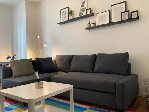 a living room with a couch and a table at Appartement avec place de parking et box vélos in Montbéliard