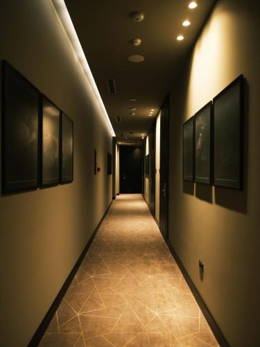 a hallway with a long corridor with paintings on the walls at The Central View Boutique Hotel in Vlorë