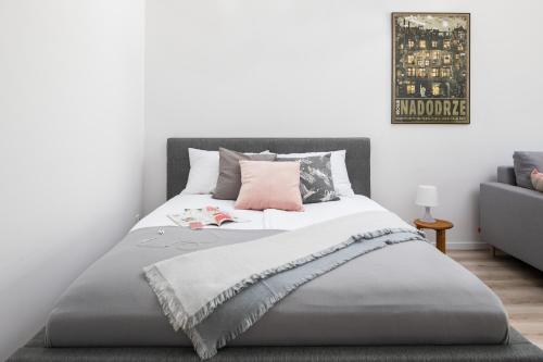 a bedroom with a bed with a pink pillow at Rent like home - River City Apartments in Wrocław