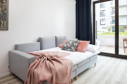 a bed with a blanket on it in a room at Rent like home - River City Apartments in Wrocław