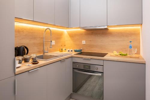 a kitchen with white cabinets and a sink at Rent like home - River City Apartments in Wrocław