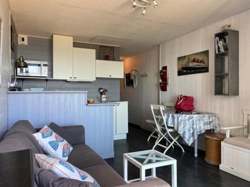 un salon et une cuisine avec un canapé et une table dans l'établissement Appartement sur la plage avec parking privé à Longeville-sur-Mer - FR-1-336-127, à Longeville-sur-Mer